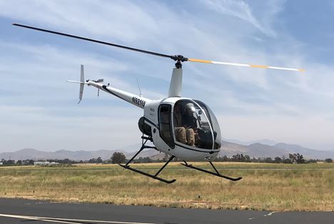 Robinson helicopter in a low hover over the runway